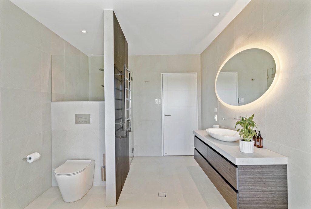Full ensuite with floating vanity and backlit oval mirror
